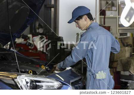 A man maintaining a car 123601827