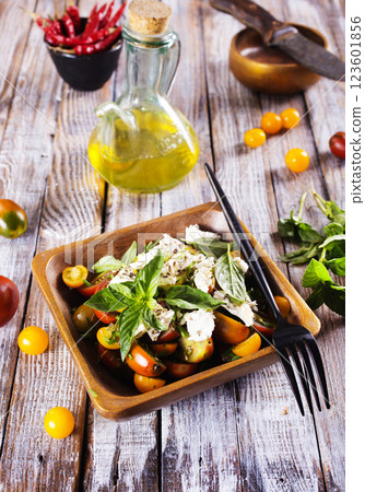 Greek salad with feta cheese and olives on wooden plate 123601856