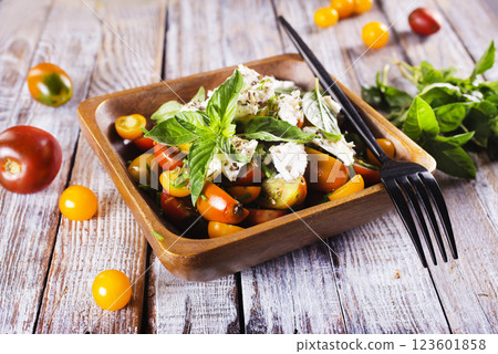 Greek salad with feta cheese and olives on wooden plate Greek salad with feta cheese and olives on wooden plate 123601858