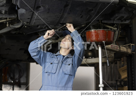 A man maintaining a car A man maintaining a car 123601923