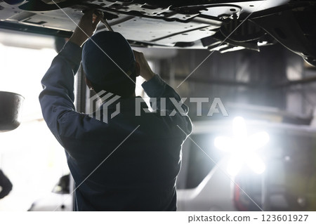 A man maintaining a car A man maintaining a car 123601927