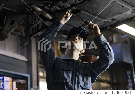 A man maintaining a car A man maintaining a car 123601931