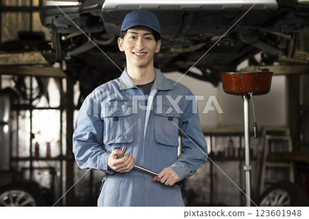 A man maintaining a car A man maintaining a car 123601948