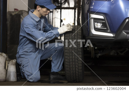 A man maintaining a car A man maintaining a car 123602004