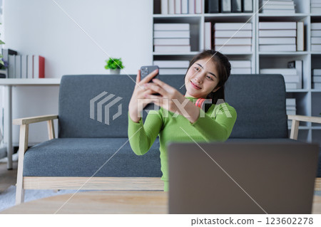 Woman taking a picture of herself in a bright and stylish home environment with modern decor and soft lighting 123602278