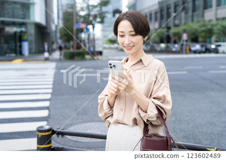 A woman using a smartphone in a city 123602489