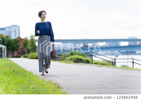 Woman walking along the seaside path Woman walking along the seaside path 123602498
