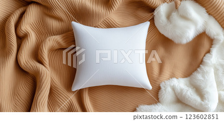 White pillow on beige blanket with fur accents 123602851