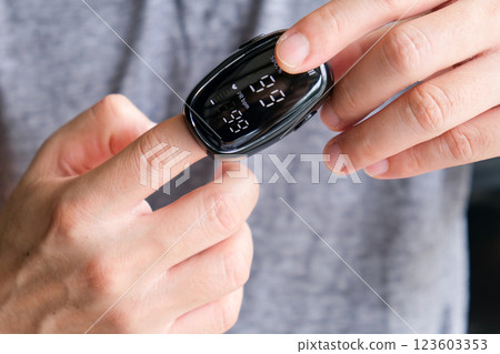 A device to measure the oxygen saturation of a person at the fingertips. And checking oxygen depletion is an emergency sign of pneumonia caused by the COVID-19 virus. A device to measure the oxygen saturation of a person at the fingertips. And checking oxygen depletion is an emergency sign of pneumonia caused by the COVID-19 virus. 123603353