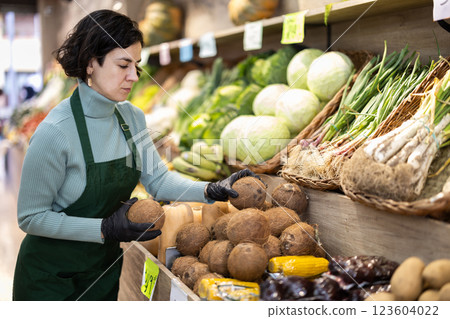 Adult woman seller puts coconuts on display 123604022