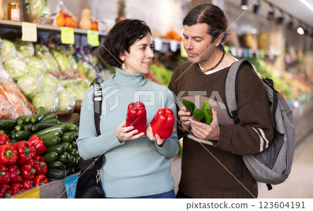 Couple chooses cucumbers and red peppers 123604191
