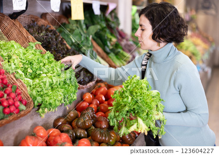 woman carefully chooses a salad woman carefully chooses a salad 123604227