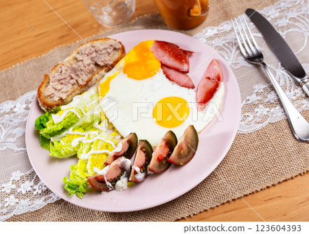 Serving plate with scrambled eggs, ham, tomatoes, brussels sprouts and tuna sandwich Serving plate with scrambled eggs, ham, tomatoes, brussels sprouts and tuna sandwich 123604393