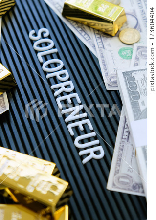 Gold bars and dollars on a black background with the word solopreneur. Gold bars and dollars on a black background with the word solopreneur. 123604404