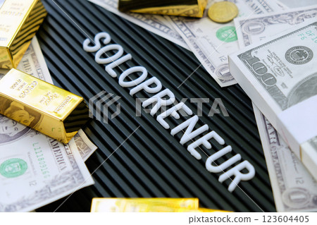 Gold bars and dollars on a black background with the word solopreneur. Gold bars and dollars on a black background with the word solopreneur. 123604405