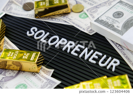Gold bars and dollars on a black background with the word solopreneur. Gold bars and dollars on a black background with the word solopreneur. 123604406
