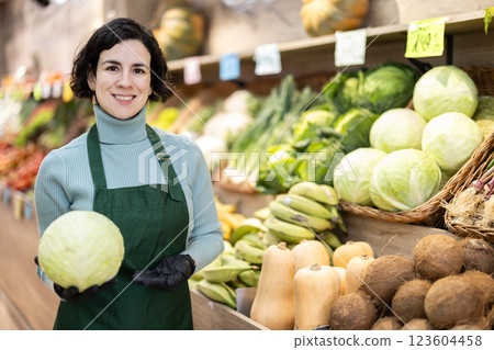 Adult woman seller with cabbage in vegetable shop 123604458