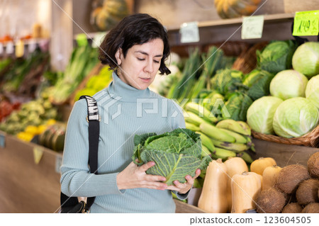 Shopping for vegetables in a supermarket - man selects cabbage Shopping for vegetables in a supermarket - man selects cabbage 123604505
