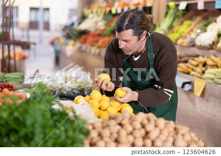 Man shop seller puts lemon goods on display case Man shop seller puts lemon goods on display case 123604626