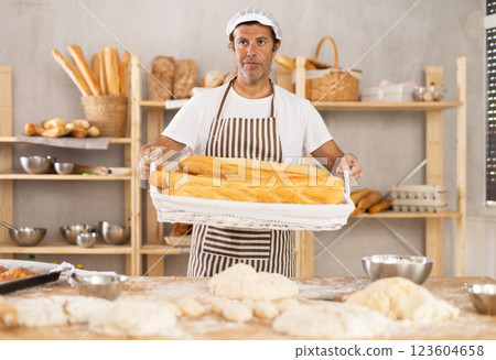 Adult male baker with basket of baguettes Adult male baker with basket of baguettes 123604658