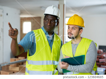 Two builders are taking notes on a tablet 123604685