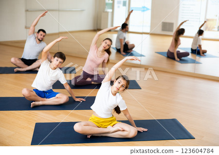 Family of four practicing yoga at gym 123604784