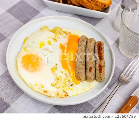 Homemade hearty breakfast - fried eggs with frankfurter and onion Homemade hearty breakfast - fried eggs with frankfurter and onion 123604789