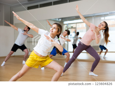 Girl exercising during family dance class Girl exercising during family dance class 123604826