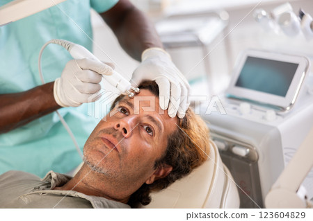 Doctor uses RF-lifting beauty machine nozzle for stimulate collagen production 123604829