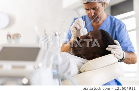 African American patient undergoing facial cryotherapy procedure at cosmetic clinic African American patient undergoing facial cryotherapy procedure at cosmetic clinic 123604911