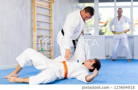 Karate sensei working out fighting techniques in kumite with young guy Karate sensei working out fighting techniques in kumite with young guy 123604918