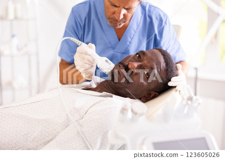 African American patient undergoing facial cryotherapy procedure at cosmetic clinic 123605026