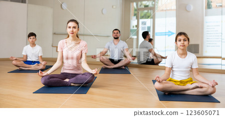 Family of four practicing yoga at gym Family of four practicing yoga at gym 123605071