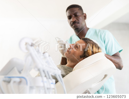 Adult male patient receiving facial procedure using cooling attachment Adult male patient receiving facial procedure using cooling attachment 123605073