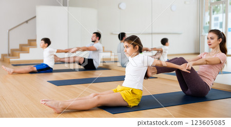 Kids and parents doing stretching exercises during yoga training Kids and parents doing stretching exercises during yoga training 123605085