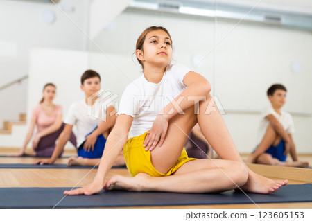 Girl practicing yoga at studio with family Girl practicing yoga at studio with family 123605153