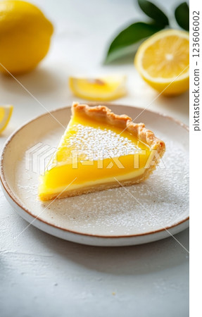 Lemon tart slice on a plate on light background 123606002