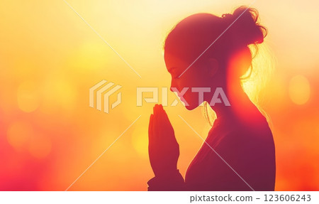 Woman praying on beautiful glowing background, religious concept 123606243