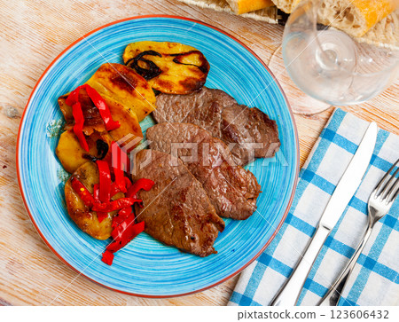 Appetizing beef entrecote with french fries and stewed bell peppers at plate Appetizing beef entrecote with french fries and stewed bell peppers at plate 123606432