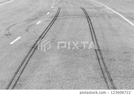 Black tire marks on asphalt road race track, Car tire track asphalt road texture and background, Abstract asphalt road background of tires tracks, Black tyre mark on asphalt road. Black tire marks on asphalt road race track, Car tire track asphalt road texture and background, Abstract asphalt road background of tires tracks, Black tyre mark on asphalt road. 123606722