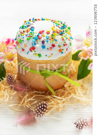 Delicious easter cake decorated with colorful sprinkles and green ribbon near spring flowers Delicious easter cake decorated with colorful sprinkles and green ribbon near spring flowers 123606758