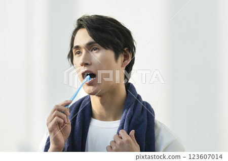 一名 20 多歲的男子正在刷牙 一名 20 多歲的男子正在刷牙 123607014