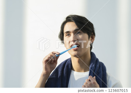 Young man brushing his teeth Young man brushing his teeth 123607015