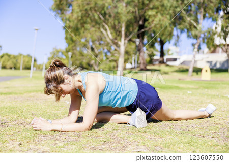 Woman stretching on the grass in the park Woman stretching on the grass in the park 123607550