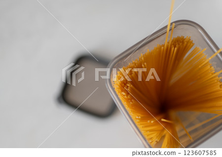 Overhead view of an open kitchen container full of spaghetti used for preparing Italian pasta dishes standing Overhead view of an open kitchen container full of spaghetti used for preparing Italian pasta dishes standing 123607585