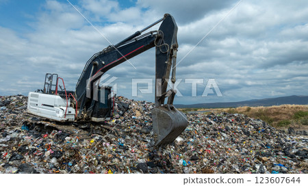 Garbage dump pile in trash dump or landfill, Landfill with waste disposal, Garbage truck unloads rubbish in landfill, Truck waste dump waste from household, Excavator work garbage waste, Aerial view. 123607644