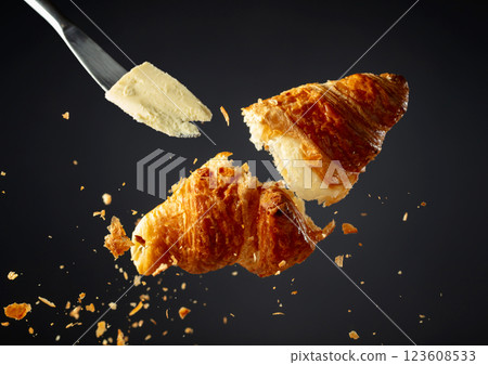 Fresh baked croissant in air and knife with butter. 123608533