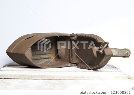 Old iron, heated by hot coals. Opened coal compartment. Located on the a wooden box. Old iron, heated by hot coals. Opened coal compartment. Located on the a wooden box. 123608861
