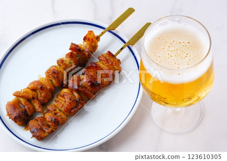 Drink beer while eating charcoal-grilled yakitori (chicken skin) with sauce. Drink beer while eating charcoal-grilled yakitori (chicken skin) with sauce. 123610305