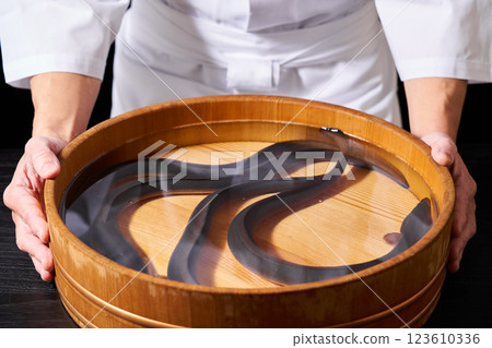 Chef holding a bucket of eels 123610336
